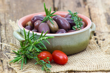 red kalamata olives, tomatoes and herbs in a bowl