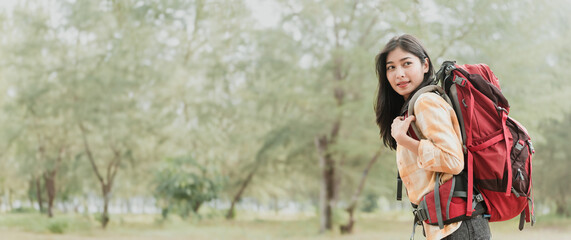 Obraz premium Asian woman hiking in the forest, feeling refreshed and energized.