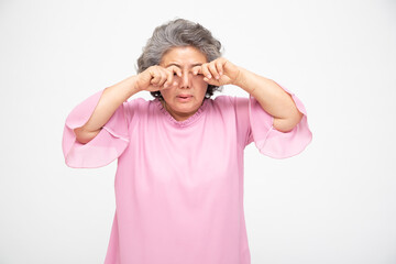 Asian senior woman with eye pain isolated on white background, Diabetic Retinopathy, Pinguecula or...