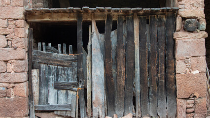 Wooden door of an old stable for animals in a rural village in Catalonia.