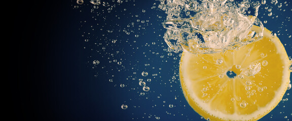 Underwater of freshly squeezed sweetened lemonade which raw lemons slice falling in soda water...
