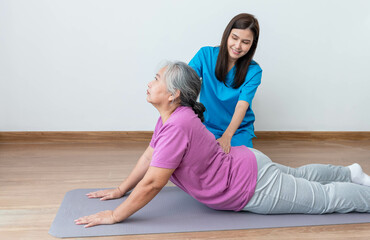 Physical therapist Asian woman, doing back and lumbar physiotherapy for elderly woman, to treat osteoarthritis and nerve pain in the backache, to nursing home and health care concept.