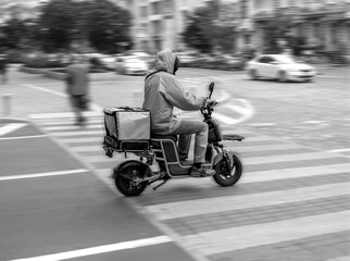 Fototapeta na wymiar Image of a courier on a scooter on a blurred background
