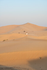 Woman taking a pictures of dunes in the desert with copy space, travel concept, desert landscape