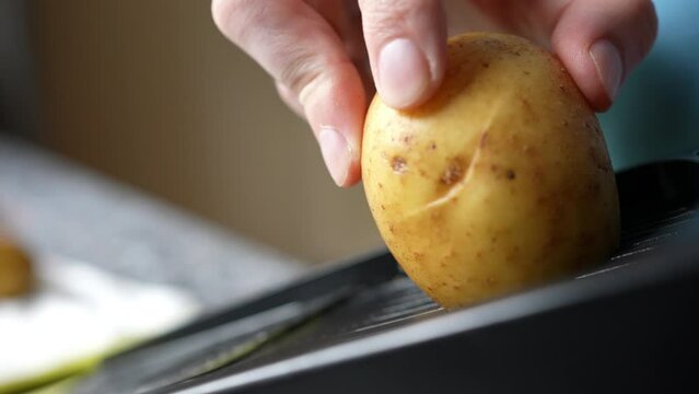 Home Cook Using Mandoline Slicer To Prepare Potato Gratin