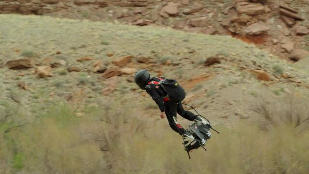 Flying man does a full spin as he flies past and continues onwards