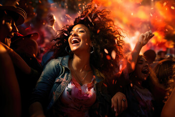 Happy cheerful young Latin woman dancing at a music festival or concert in a crowd of people