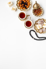 Muslim holiday concept - tea cups and Muslim rosary with a crescent moon