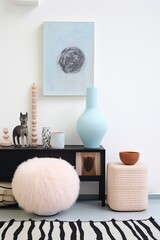 This minimalist pastel interior design features a vase, a cat, and furniture arranged in a cozy room, creating a peaceful and inviting atmosphere