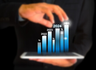  tablet in hand and 2024 chart showing annual growth and success and 2024 ideas.