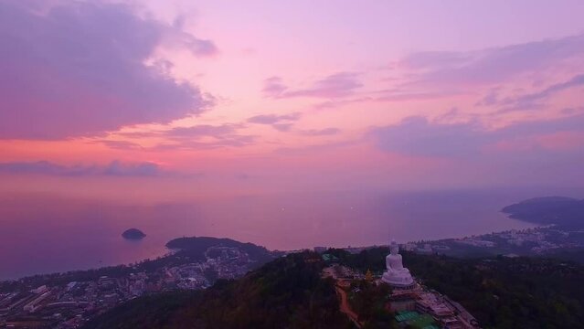.aerial view stunning pink sky in sweet sunset at Phuket big Buddha. .the sun shines through the clouds impact on ocean surface .The beauty of the statue fits perfectly with the charming nature.