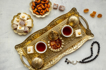 Ramadan party table with tea on bronze tray and Muslim rosary with a crescent moon