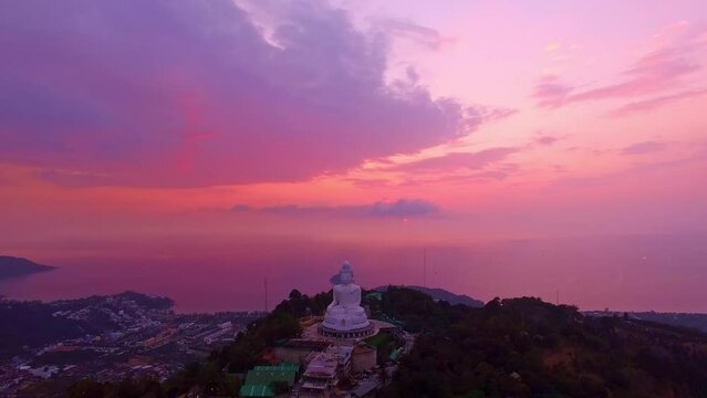 .aerial view colorful pink cloud in sweet sky at sunrise behins the Phuket big Buddha..creative travel concept. stunning pink sky background..Phuket big Buddha is the popular landmark in Phuket.