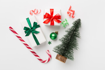 Miniature christmas tree with gift box and decor on color background