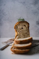 Tuinposter Fresh Sliced Homemade Wholegrain Wheat Bread on white rustic background. Artisan Sourdough © ILHAM_PS