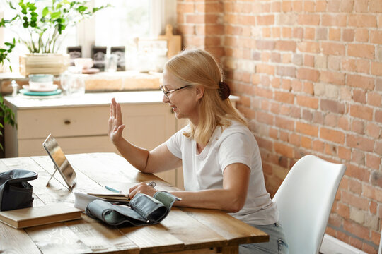 Telemedicine. Mature patient is talking on a video call with the doctor. A virtual physician consults a woman online on tablet at home. Control health