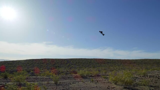 Flying through desert with a jet pack hooked to feet at fast speeds