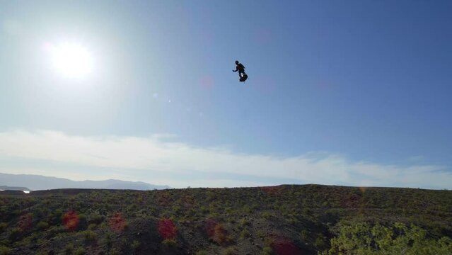 Man flying in slow motion with jet pack in desert in slow motion