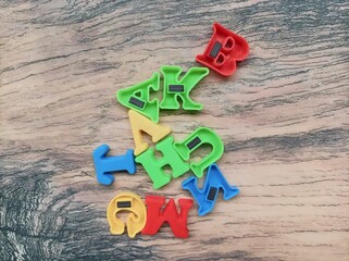 Colorful alphabet letters for preschoolers education. Closeup shot of magnetic multicolor letters isolated on a marble table background. Magnetic letter toys for children's play.