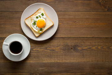 Breakfast with fried eggs on toast bread and cup of black coffee