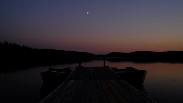 un quai avec des bateaux sur un lac au cr&eacute;puscule dans la r&eacute;serve faunique des Laurentides