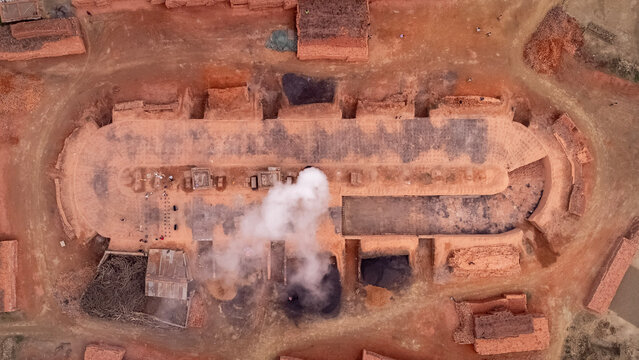 Top-Down View of a Brick Kiln with Smoke Emitting from the Chimney