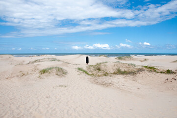 Man in sorcerer costume walking on the dunes of the beach