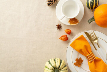 The fall-inspired concept of Thanksgiving feast is showcased from bird's-eye view. Gilded table settings and seasonal decor on beige tablecloth isolated setting, with space for text or advertisements