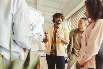 Young confident manager explaining strategy to colleagues during meeting