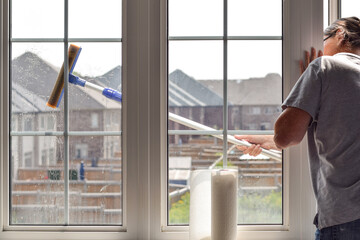 Woman washing dirty windows with telescopic window cleaning pole