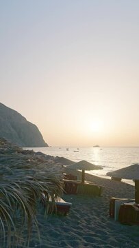 Umbrellas and Sunbeds at Perissa Beach in Santorini in the Morning Vertical Video