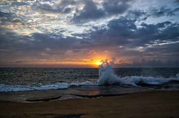 sunset over the sea, big waves and cloudy sky