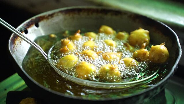 Indian young Woman Preparing Pakoda or pakora for guest
