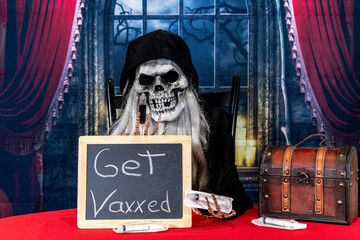 Grim Reaper on red giving out vaccines for Halloween with spooky night window background
