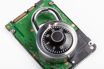 Closed code padlock laying on top of a HDD hard drive, object detail, closeup, disk data encryption, files locker password protection user data safety policies, cyber security abstract concept, nobody