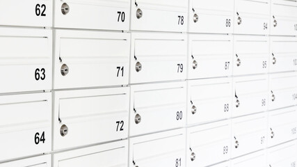 Lots of white private mailboxes, wall of many letterboxes in a flat apartment condo complex, object detail, closeup. Postal service, receiving mail messages abstract concept, nobody