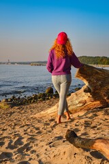 Morning scene with a woman on the beach. Female tourist on the beach in Gdynia on the Baltic Sea in Poland admiring the views. - 652980981
