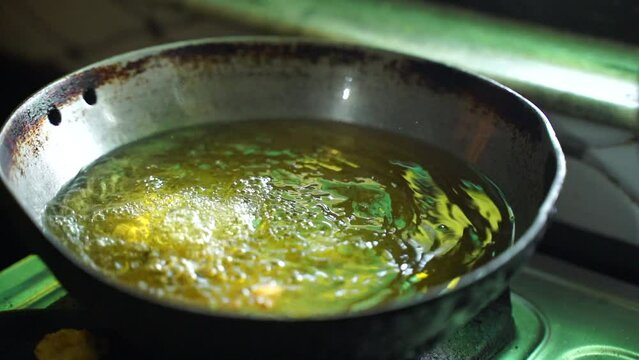 A first drop og pakora, Making a padoka or pakora by hand a young woman in Indian homes