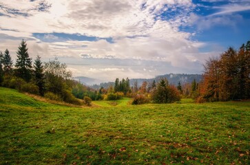 Countryside landscape. Glade in mountains in autumn with hills and forest at the background, Beskidy mountains, Poland. - 652985130