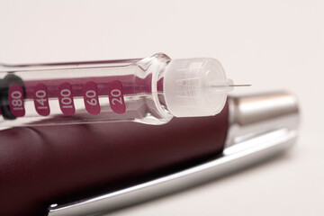 Insulin pen injector. Insulin pen fill with needle on white background. Diabetes Day.