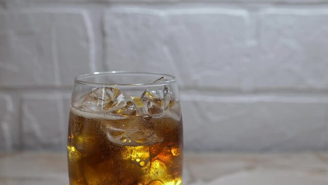 cold drink video: cola sparkling in glass with ice