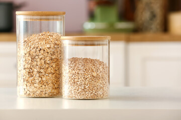 Jars with different cereals on table in kitchen