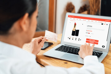 Woman shopping online on internet marketplace browsing for sale items for modern lifestyle and use credit card for online payment from wallet protected by uttermost cyber security software - obrazy, fototapety, plakaty