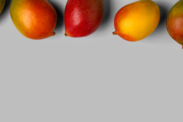 Fresh ripe mangoes on light background