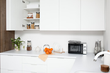 White counters with food and utensils in light kitchen