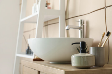 Sink bowl and bath accessories on table in bathroom