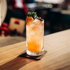 Citrus alcohol cocktail with tangerine juice and grenadine glass with mandarin slice and mint.