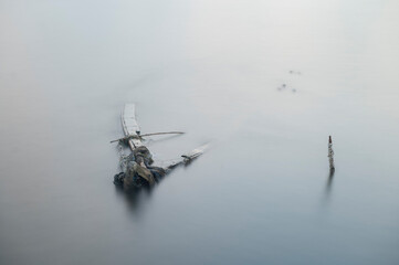 A sunken boat and a stick full of shells on a beach are a reminder of the power of nature and the...