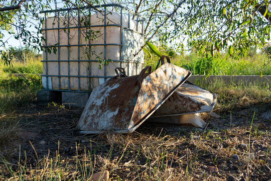 Image of metal containers to make concrete stacked in a field, oxidized and old due to the time that they lead to the interperie.