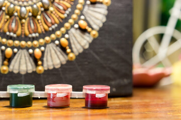 Jars of paint on the background of a canvas with a painted mandala. Shallow depth of field. Focus on a can of red paint.